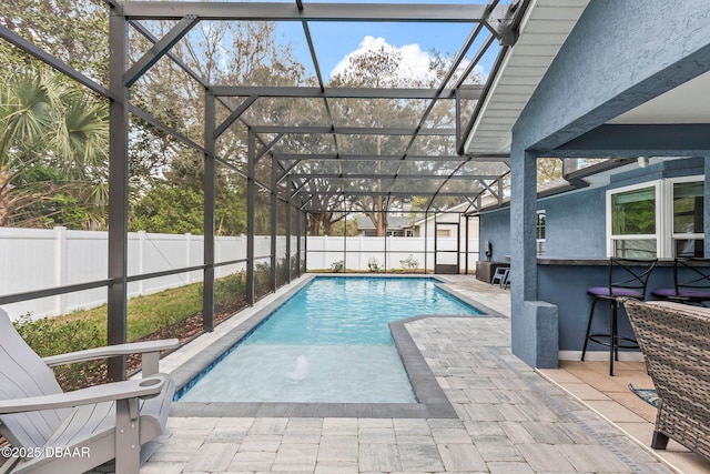 view of pool with a patio area, glass enclosure, a fenced backyard, and a fenced in pool