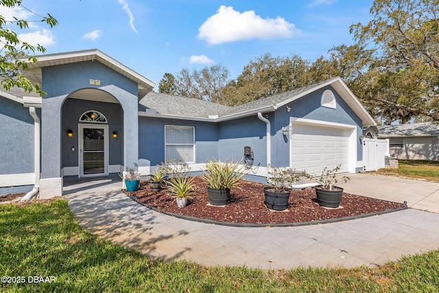 single story home featuring a garage, roof with shingles, concrete driveway, and stucco siding