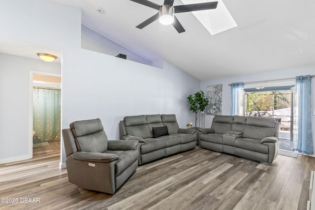 living room featuring high vaulted ceiling, a skylight, and wood finished floors