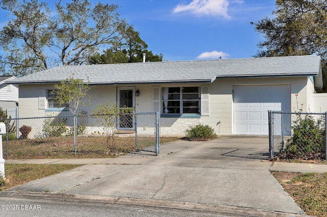 ranch-style home with a fenced front yard, concrete driveway, roof with shingles, concrete block siding, and an attached garage