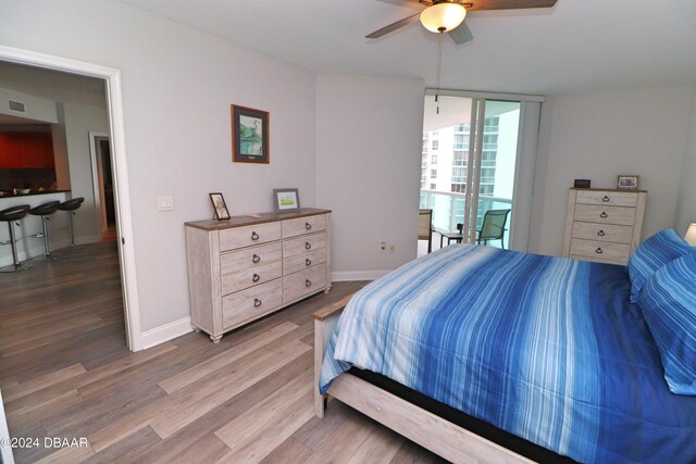 231 Riverside Dr Unit 1106-1, Holly Hill, FL 32117 - bedroom with wood finished floors, baseboards, a wall of windows, and ceiling fan