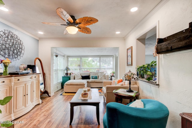 living room featuring ornamental molding, light hardwood / wood-style flooring, and ceiling fan