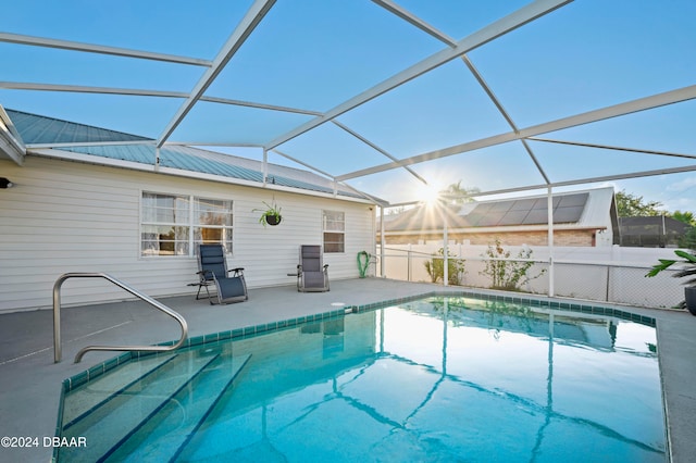 view of swimming pool featuring glass enclosure and a patio