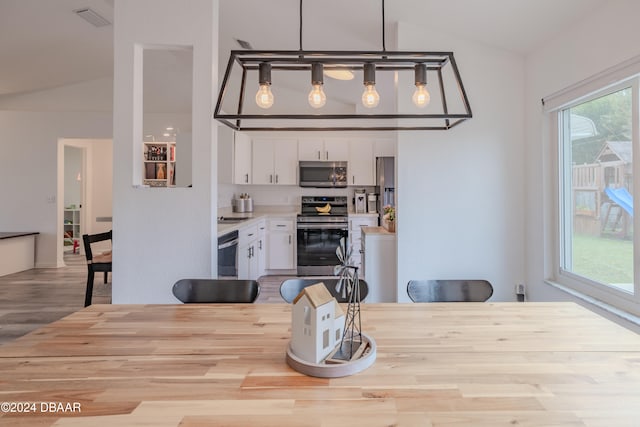 dining room with lofted ceiling and light hardwood / wood-style floors