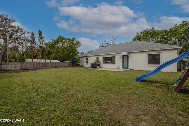 rear view of property with a patio, a playground, and a yard