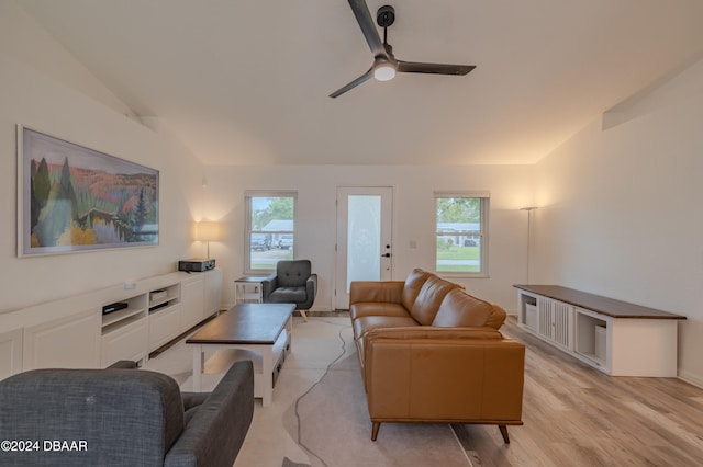 living room with ceiling fan, light wood-type flooring, and vaulted ceiling