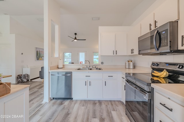 kitchen featuring white cabinetry, light wood-type flooring, appliances with stainless steel finishes, and sink