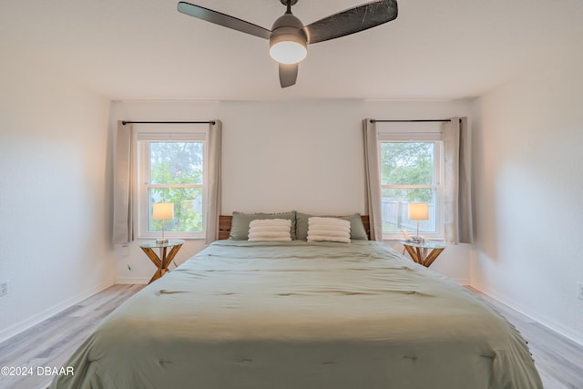 bedroom featuring light wood-type flooring, multiple windows, and ceiling fan