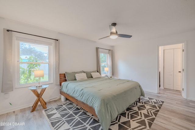 bedroom with light wood-type flooring, multiple windows, and ceiling fan