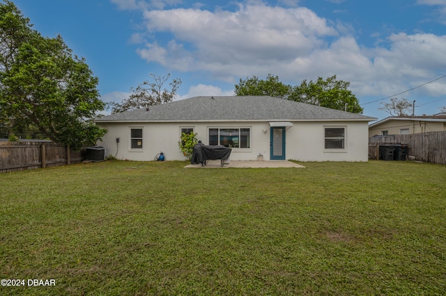 rear view of house with a patio, central AC, and a yard