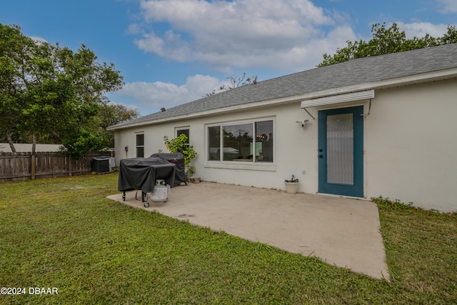 back of property with a lawn, central AC, and a patio area