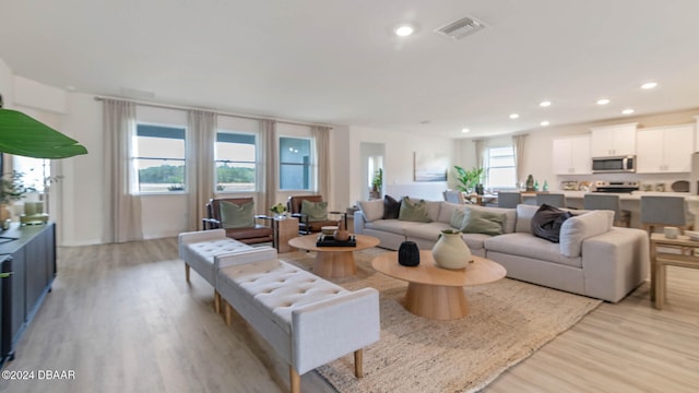 living room with a wealth of natural light and light hardwood / wood-style flooring