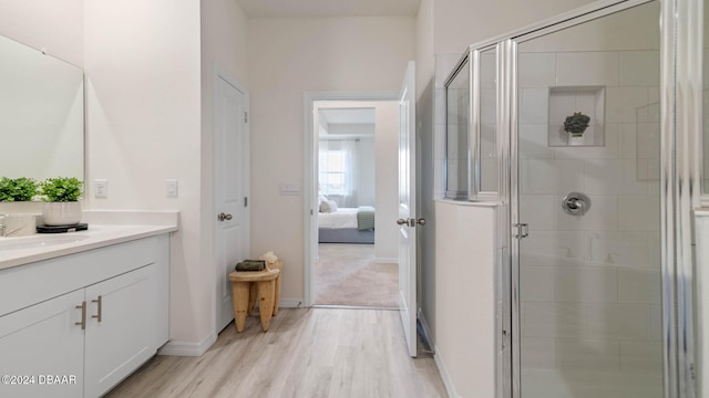 bathroom featuring hardwood / wood-style floors, vanity, and a shower with door