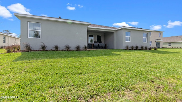 back of property featuring a lawn