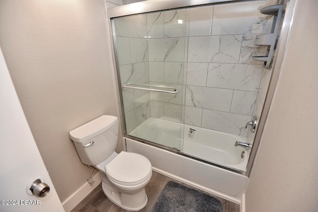 bathroom with toilet, bath / shower combo with glass door, and hardwood / wood-style flooring