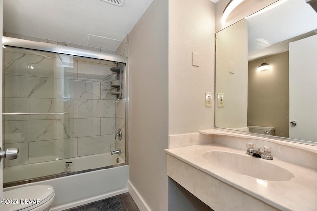 full bathroom featuring vanity, toilet, and bath / shower combo with glass door