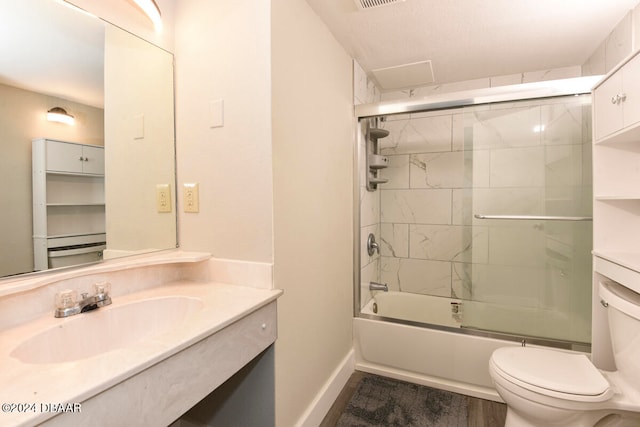 full bathroom featuring sink, enclosed tub / shower combo, and toilet