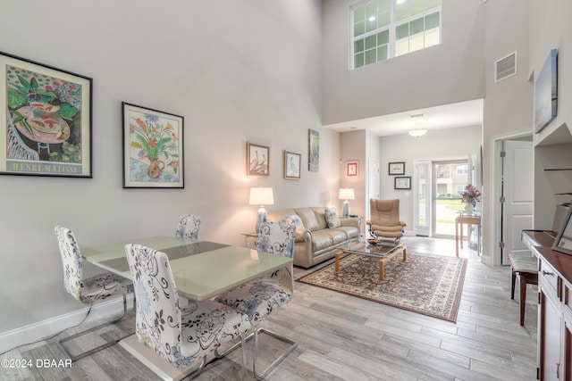 living room featuring light hardwood / wood-style floors and a high ceiling