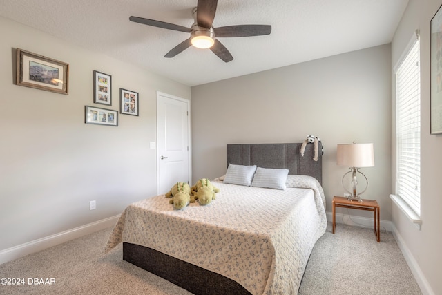 carpeted bedroom with multiple windows, ceiling fan, and a textured ceiling