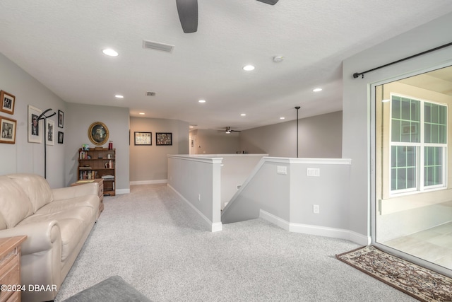 carpeted living room featuring a textured ceiling, plenty of natural light, and ceiling fan