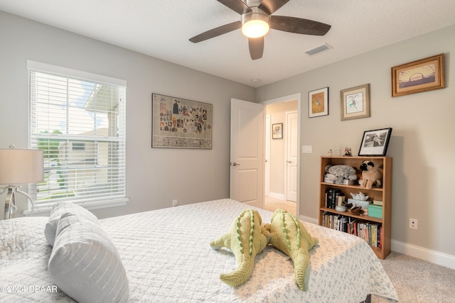 carpeted bedroom featuring ceiling fan and a textured ceiling