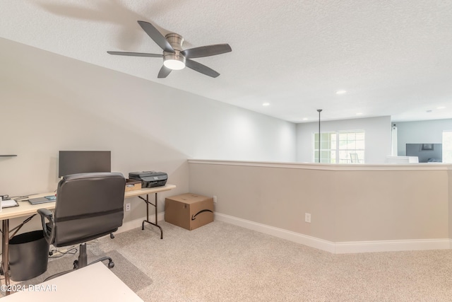 carpeted office with a textured ceiling and ceiling fan