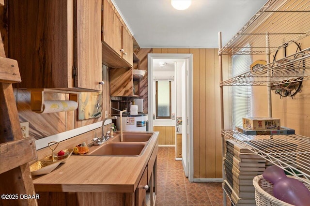 771 Arroyo Pkwy, Ormond Beach, FL 32174 - kitchen featuring a sink, wooden walls, brown cabinetry, and dark flooring