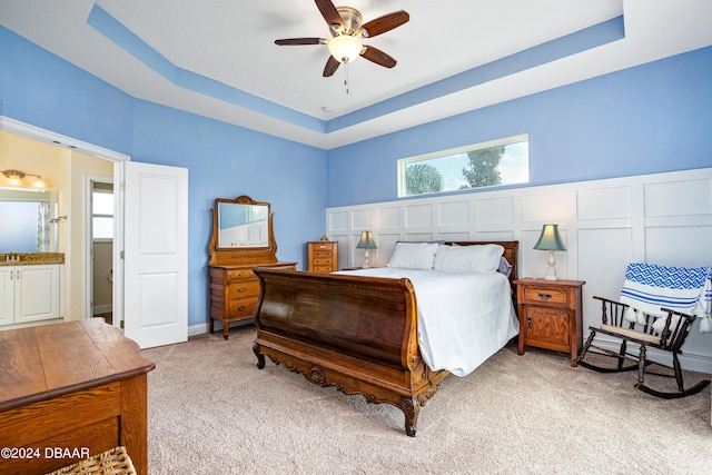 3651 Pini Ave, New Smyrna Beach, FL 32168 - bedroom with ensuite bathroom, ceiling fan, light carpet, and a raised ceiling