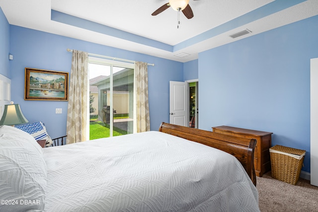 3651 Pini Ave, New Smyrna Beach, FL 32168 - carpeted bedroom with ceiling fan, access to exterior, and a tray ceiling