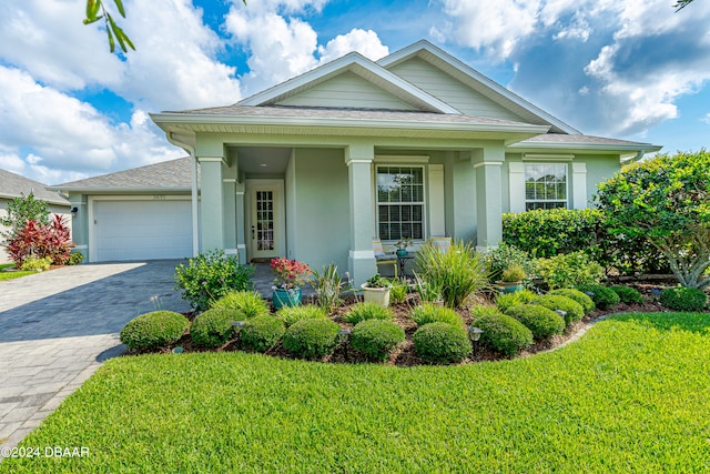 3651 Pini Ave, New Smyrna Beach, FL 32168 - view of front of home with a front lawn, a garage, and a porch