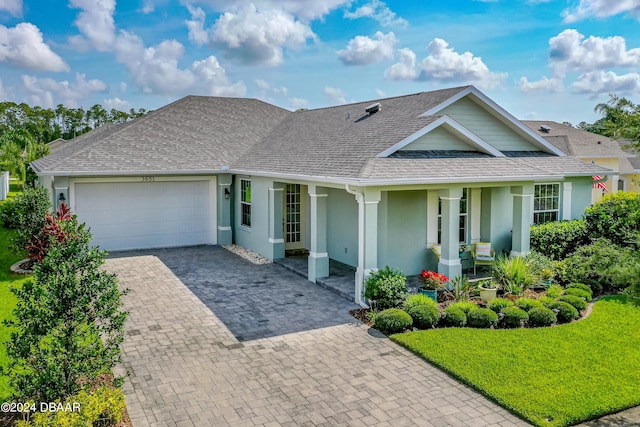 3651 Pini Ave, New Smyrna Beach, FL 32168 - view of front facade featuring a front lawn, a garage, and a porch