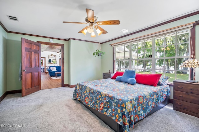 carpeted bedroom with ceiling fan, multiple windows, and crown molding