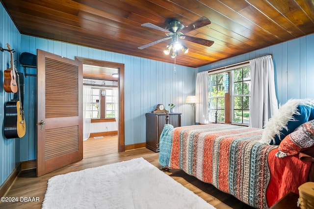 bedroom with wooden ceiling, ceiling fan, multiple windows, and light wood-type flooring