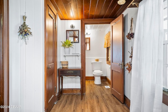 bathroom featuring wooden ceiling, hardwood / wood-style flooring, and toilet