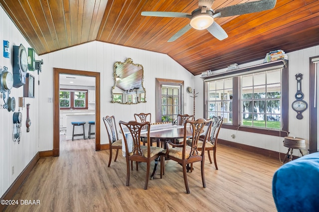 dining space featuring wood walls, wood ceiling, light hardwood / wood-style floors, lofted ceiling, and ceiling fan