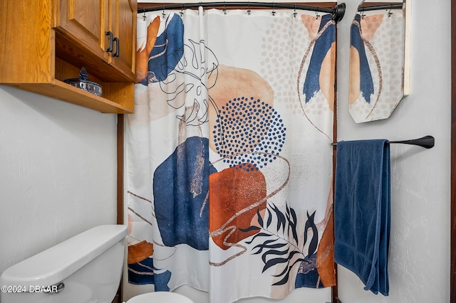 bathroom featuring a shower with curtain and toilet