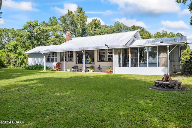 rear view of property with a sunroom and a yard