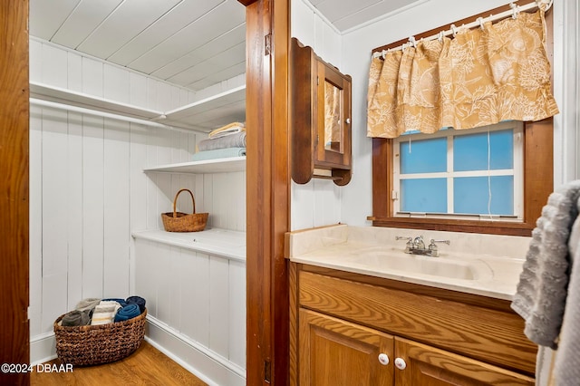 bathroom with vanity, hardwood / wood-style flooring, and wooden walls