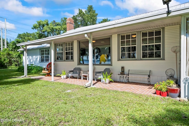 rear view of property with a patio and a yard