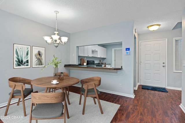 dining space with an inviting chandelier, a textured ceiling, and dark wood-type flooring