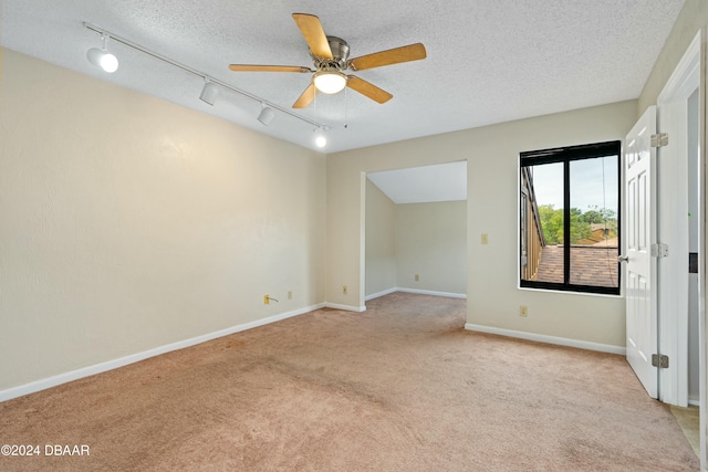 carpeted spare room featuring ceiling fan, rail lighting, and a textured ceiling