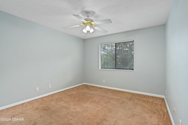 carpeted spare room featuring ceiling fan and a textured ceiling