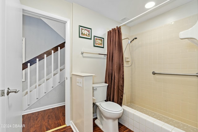 bathroom with toilet, hardwood / wood-style floors, and a shower with curtain