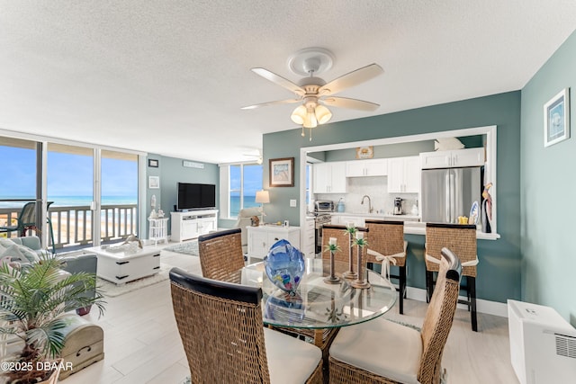 2800 N Atlantic Ave Unit 515, Daytona Beach, FL 32118 - dining area with ceiling fan, a textured ceiling, and a wall of windows