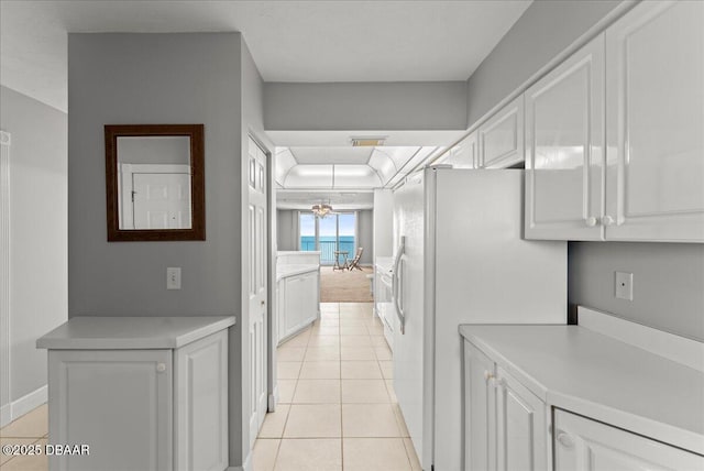 3425 S Atlantic Ave Unit 902, Daytona Beach Shores, FL 32118 - kitchen with white fridge with ice dispenser, white cabinetry, light countertops, and light tile patterned floors