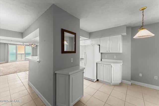 3425 S Atlantic Ave Unit 902, Daytona Beach Shores, FL 32118 - kitchen with white refrigerator with ice dispenser, light tile patterned flooring, white cabinets, light countertops, and baseboards