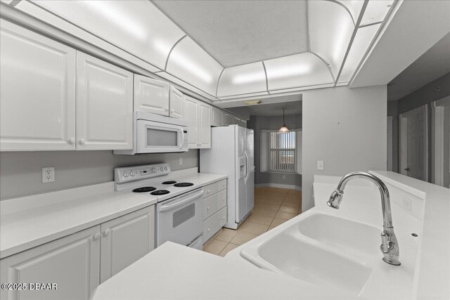 3425 S Atlantic Ave Unit 902, Daytona Beach Shores, FL 32118 - kitchen featuring white appliances, a sink, white cabinetry, light tile patterned floors, and light countertops