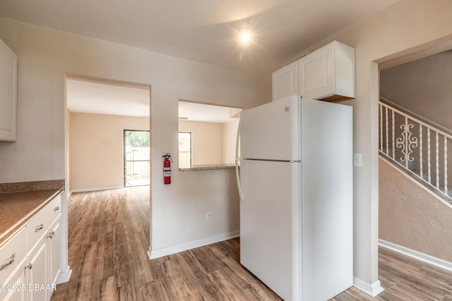 108 Mitchell Pl, Daytona Beach, FL 32118 - kitchen featuring freestanding refrigerator, wood finished floors, white cabinets, and baseboards