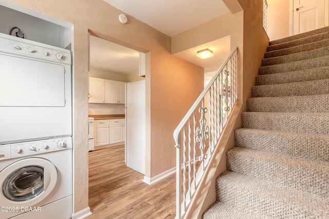108 Mitchell Pl, Daytona Beach, FL 32118 - stairs with stacked washer and clothes dryer, wood finished floors, and baseboards