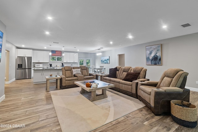 living room featuring light hardwood / wood-style floors and a notable chandelier